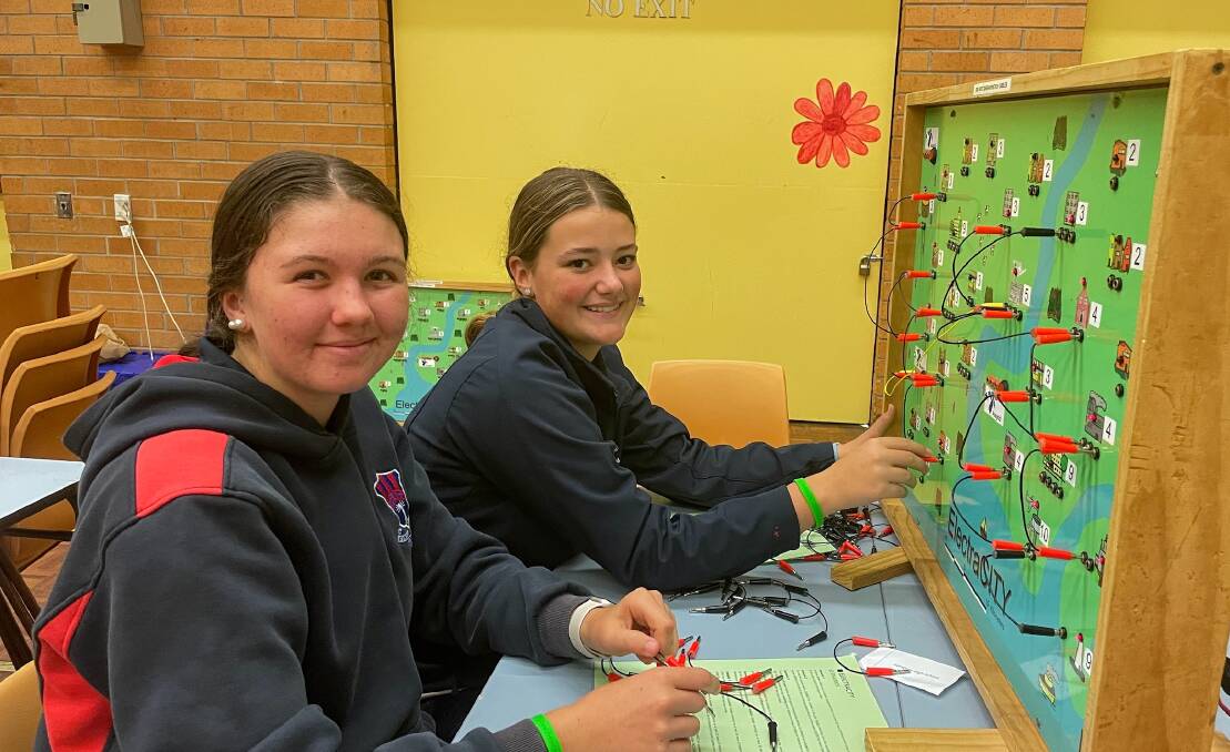 Kempsey High School students Ebony Haywood and Lylah Weismantel are helping power electricity across a map for the Science and Engineering Challenge. Picture by Emily Walker